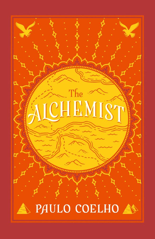 cover for the book The Alchemist, showing a sun emitting rays in the center. On the top corners are two eagles, and on the bottom three pyramids (two on the right corner). In the sun, a map of the Strait of Gibraltar can be seen, with a dotted line marking a path from Spain in the North fo Morocco in the south and beyond. the title in the center of the sun reads "The Alchemist", and the author's name is at the bottom of the illustration: Paulo Coelho