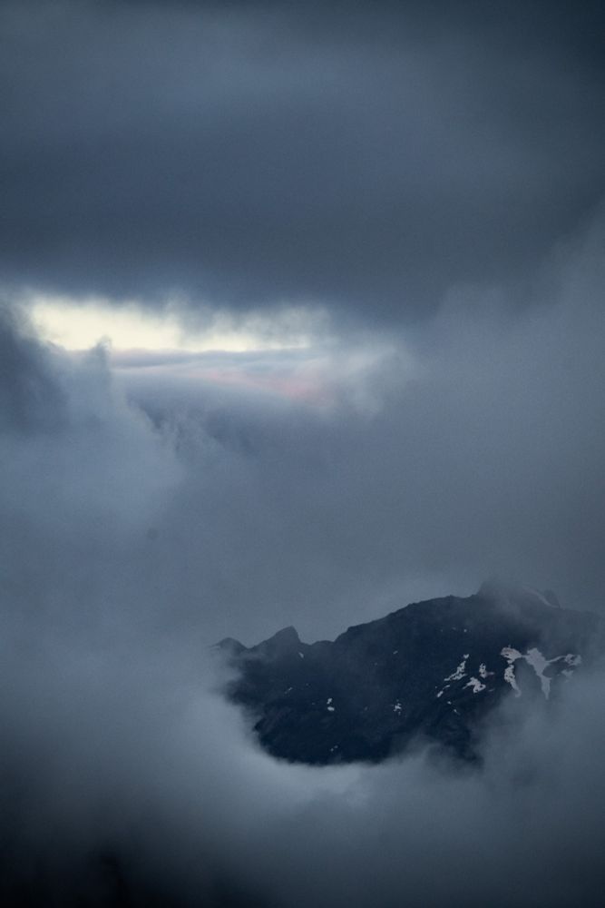 A picture of a mountain top hidden in the clouds.
