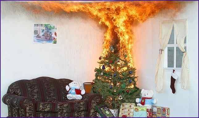 A picture of a Christmas tree with wrapped presents and a couple of stuffed animals at its base. There's a couch, a picture on the wall and a window with a stocking hanging in it and curtains. Oh, and the Christmas tree is on fire, flames shooting to and spreading across the ceiling.