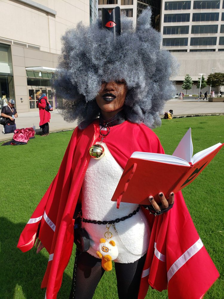 An absolute god of a person with a massive afro cosplaying as The Lamb from Cult of the Lamb