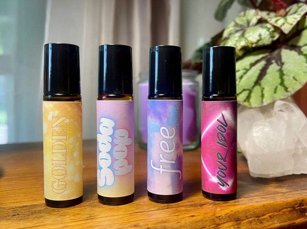 Four bottles of roll on perfume oil: Golden, Soda Pop, Free, and Your Idol