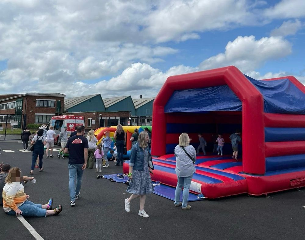 Fun day at Scoil na Seolta with grass bank, bouncy castles and people milling around. 