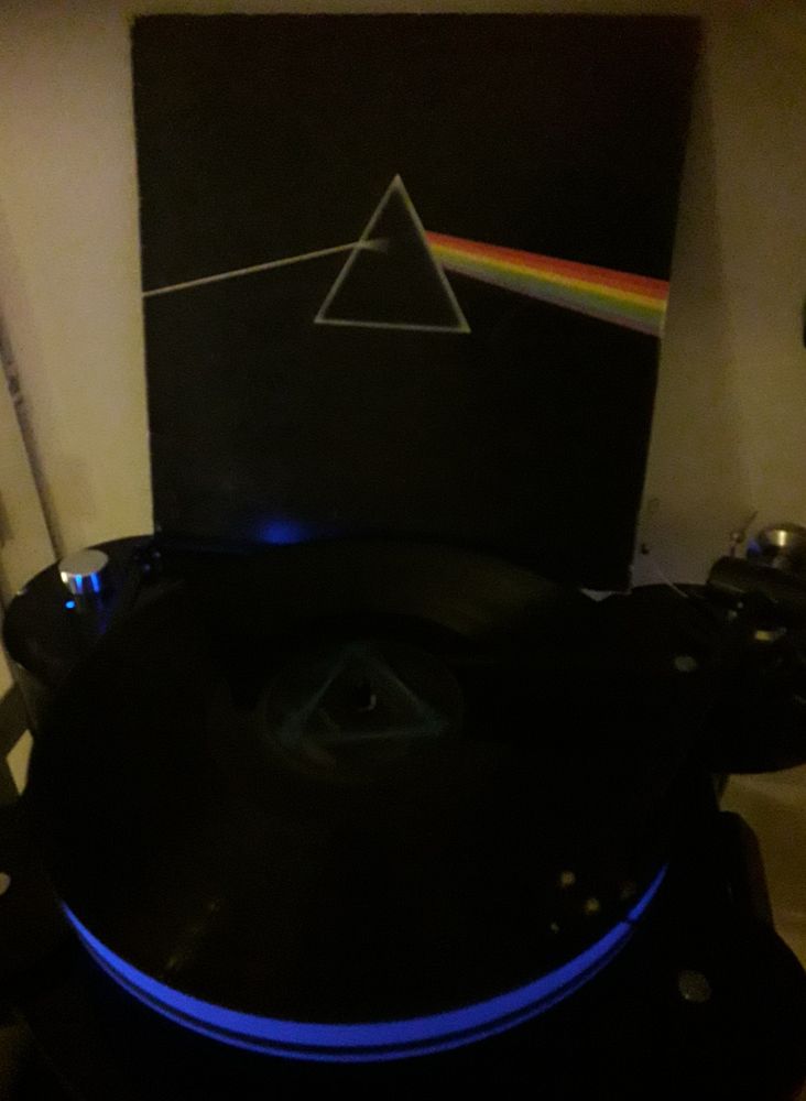 The iconic record cover behind a black record player playing the disc 