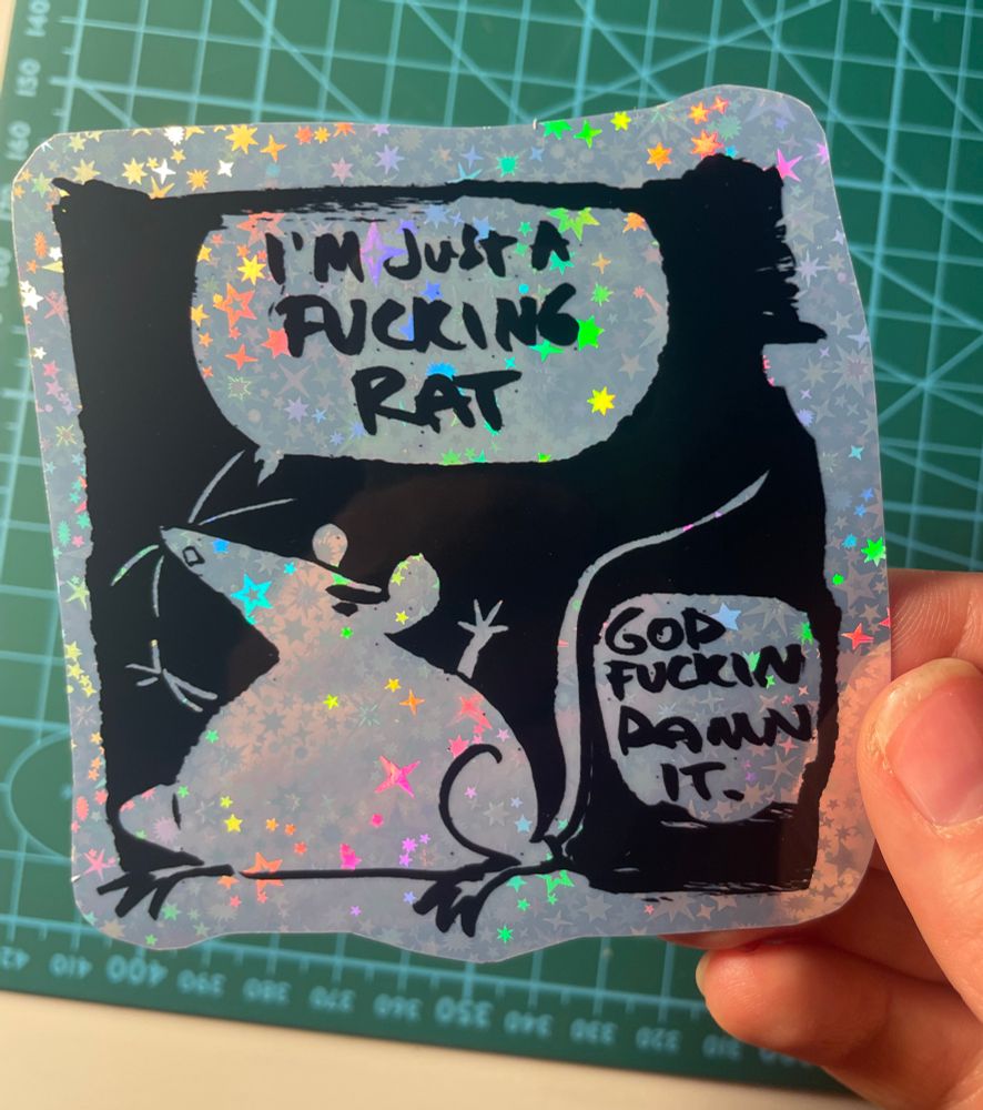 A sweary rat sticker printed on holographic sparkly rainbow vinyl.

Absolutely trashing my somewhat dark femme comics aesthetic with these things and enjoying it lots. 