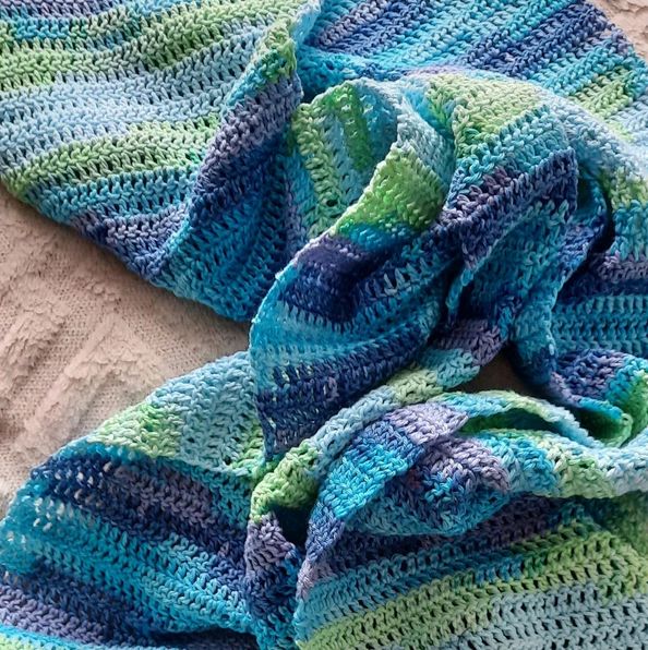 Gehäkelter Schal in Stäbchenmasche mit wechselnden Farben zwischen Dunkelblau, Hellila, Türkis, Hellgrün und Hellblau