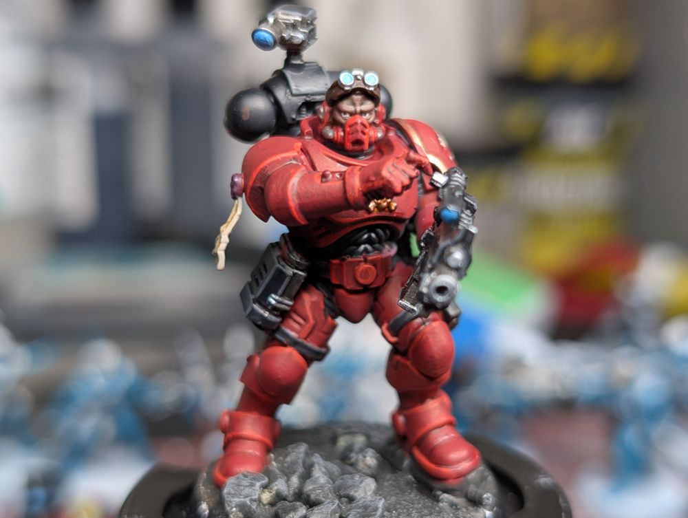 Close up of Exorcist marine marksman with goggles on forehead, looking to the side as he adjusts a dial on his scopes rifle.