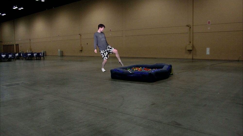 Chili is stepping into a small ball pit in an empty convention center hall