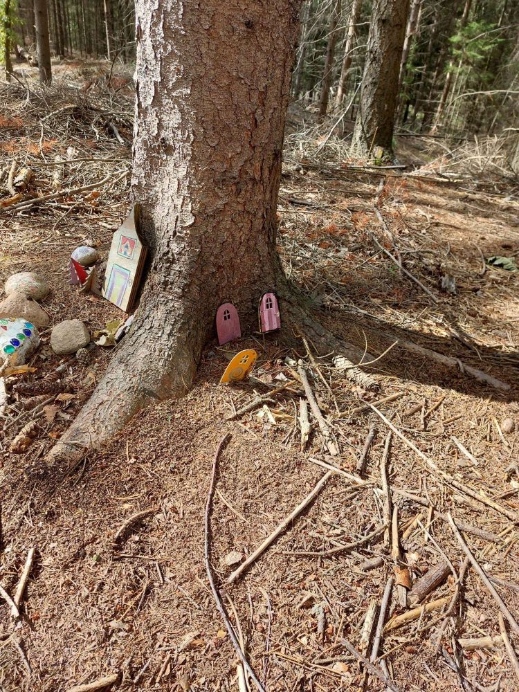 Kleine bunte Wichteltüren an einem Baumstamm