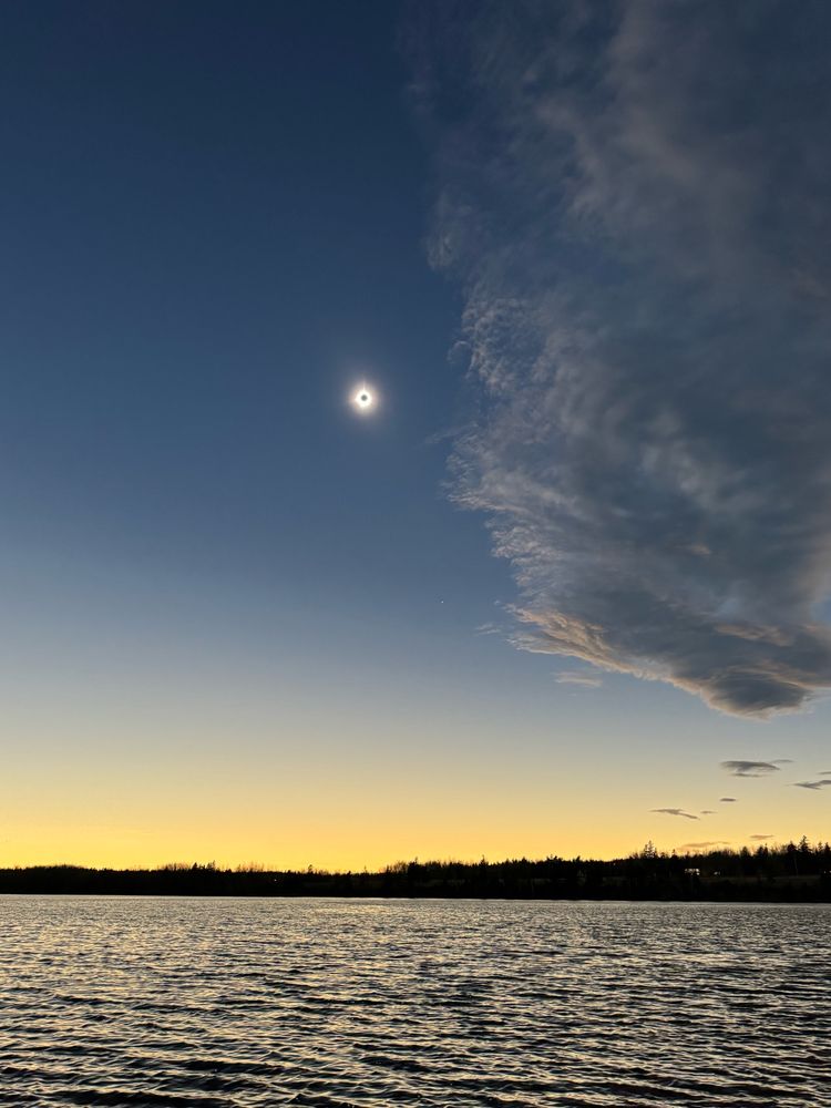 A picture of an orange and blue sky, with a solar eclipse in the middle 