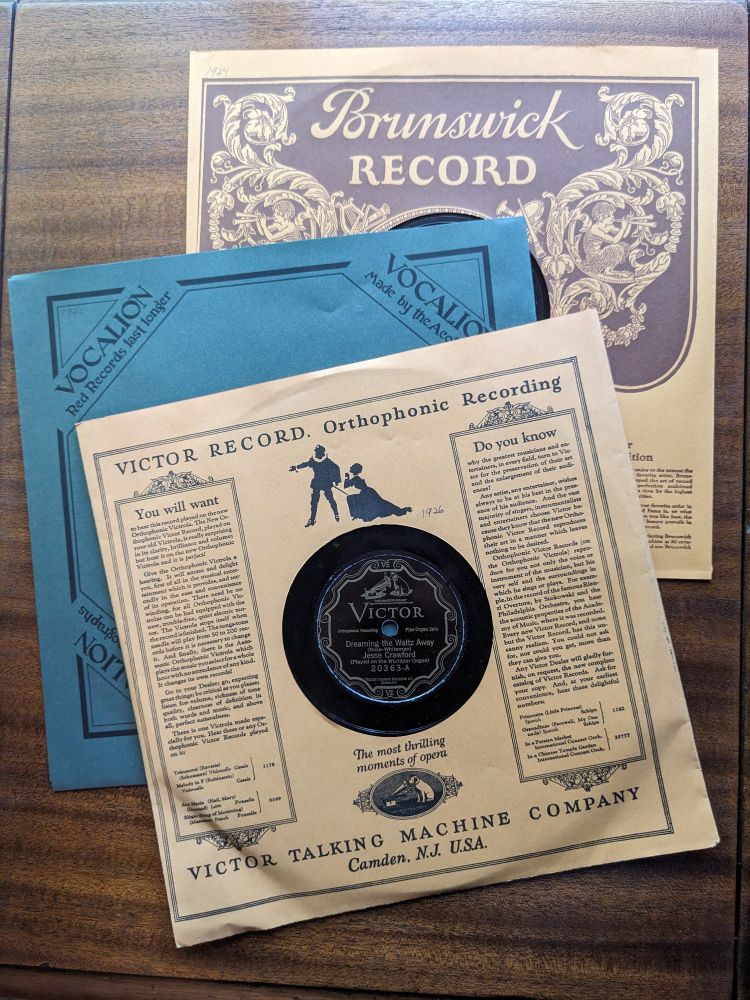 three 78 rpm record sleeves, a 1923 Brunswick, a 1922 Vocalion, and a 1926 Victor