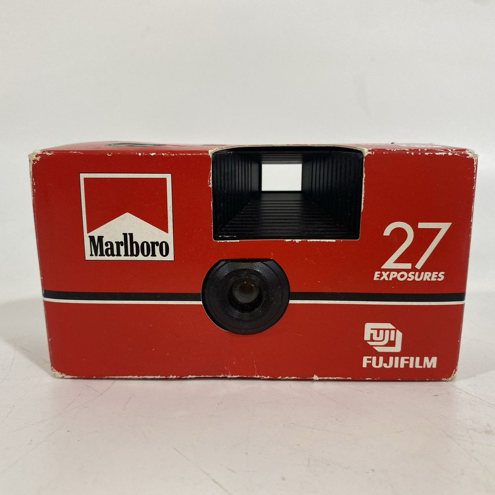 A red cardboard Marlboro branded camera, featuring a tunnel viewfinder and advertised as having 27 exposures on Fulifilm filmstock