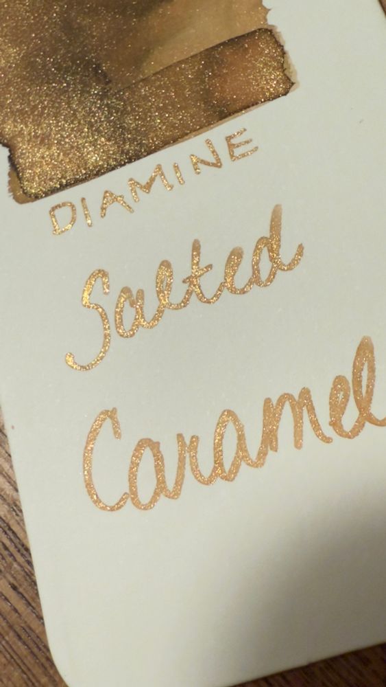 Ivory paper tag with an warm golden with shimmer ink swatch and the words Diamine Salted Caramel