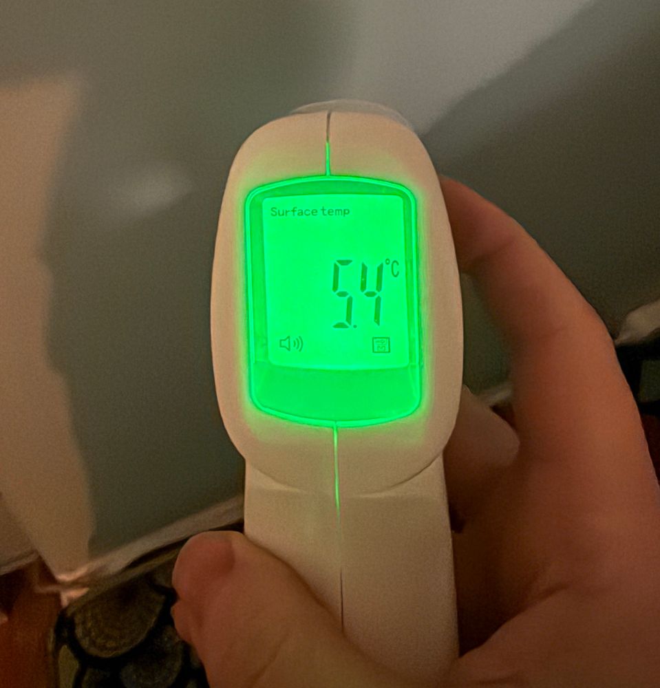 Handheld digital thermometer with a green screen and 5.4°C
