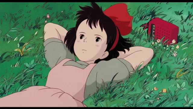 a girl in a pink apron is laying in the grass with her hands behind her head