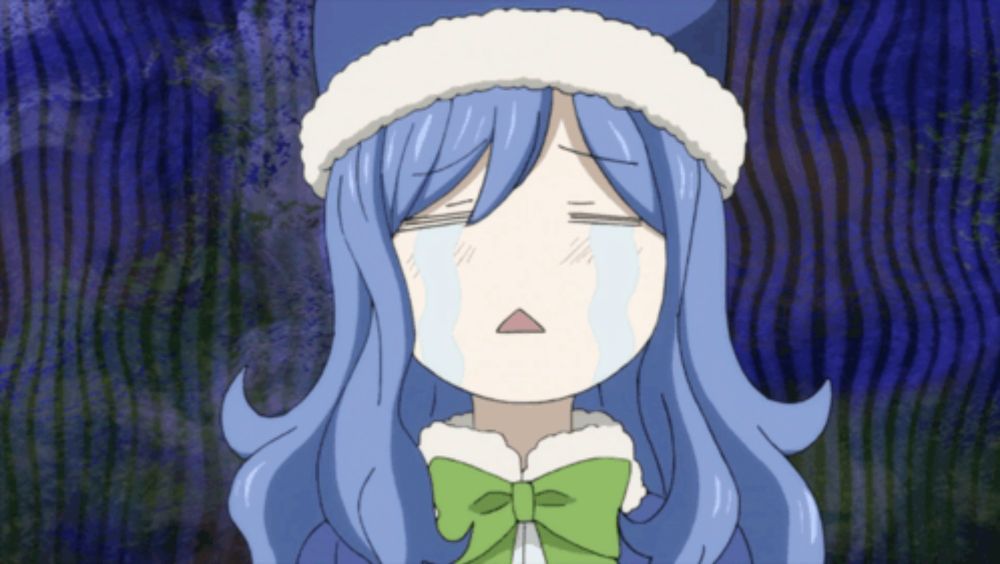 a girl with blue hair and a green bow is crying with her eyes closed