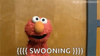 elmo from sesame street is sitting in front of a wooden wall and saying swooning .