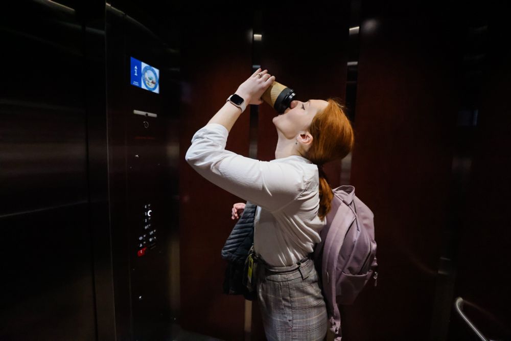 McKenna chugs a coffee while in an elevator heading to her next interview. 