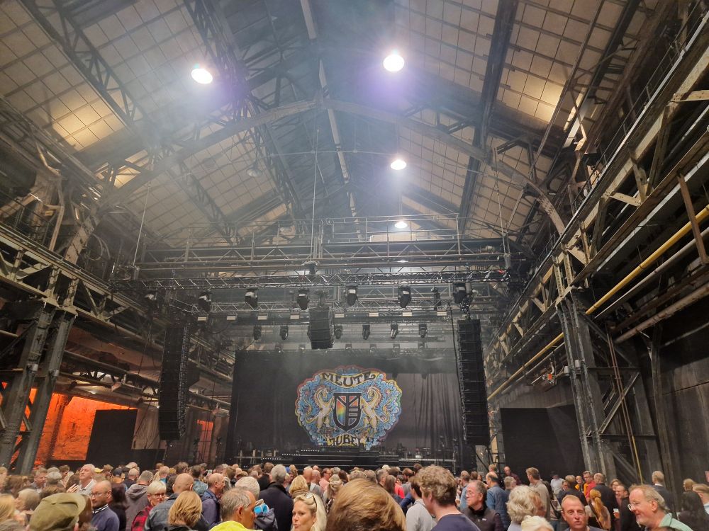 Bühne der Band Meute in der Jahrhunderthalle Bochum, davor wartende Menschen.