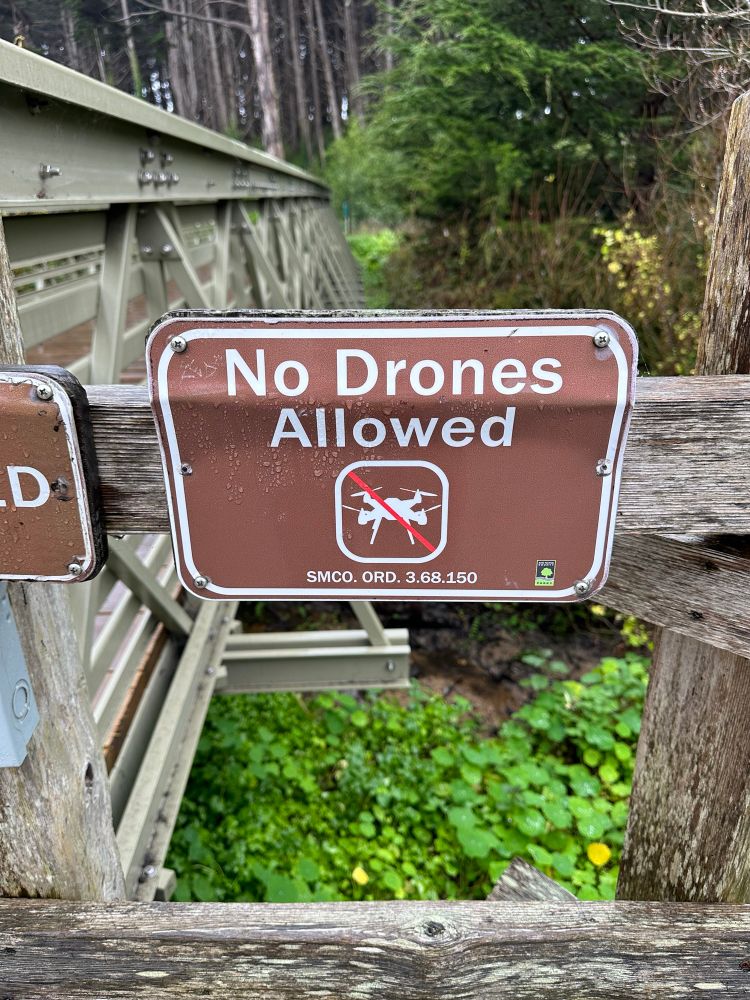 no drones allowed sign on a coastal trail 