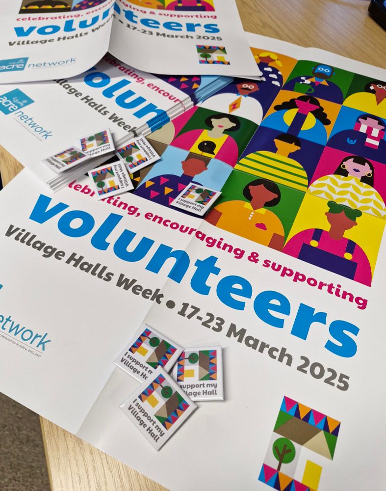 Photo shows posters and badges promoting Village Halls Week 2025, a week long celebration in March of all the volunteers behind the wonderful network of rural assets which sit at the heart of our communities.