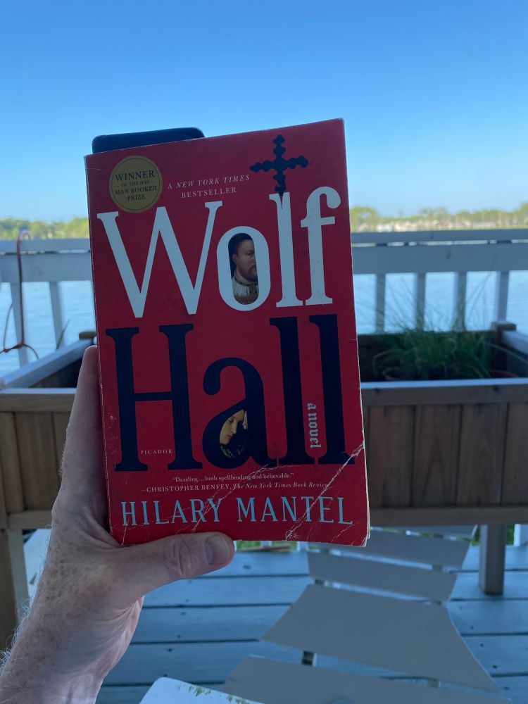 Holding up Hilary Mantel’s Wolf Hall with a Chesapeake Bay cove in the background