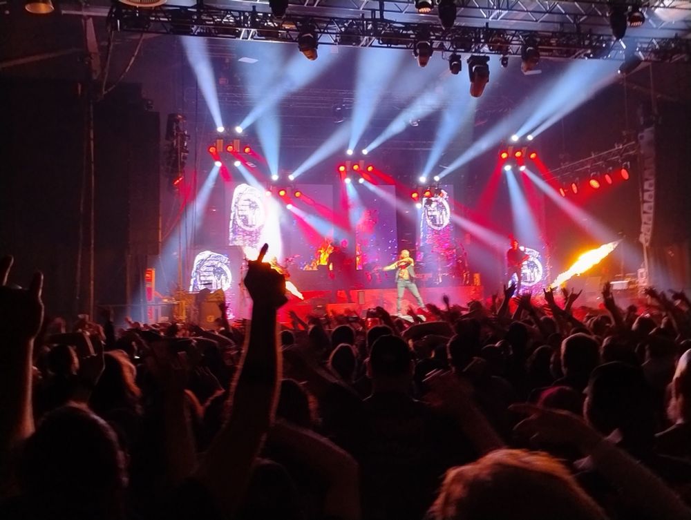 Saltatio Mortis Konzert Bühne:
pink-Rote Beleuchtung und Hintergrund, der Sänger vorne im Spotlight