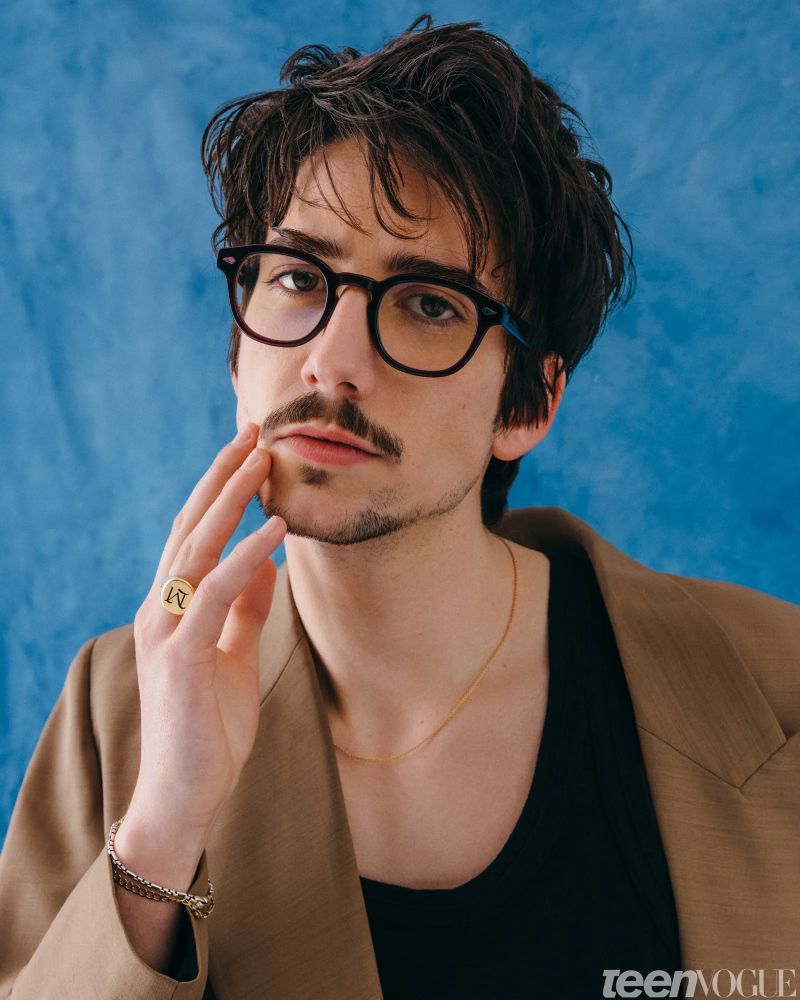 Milo Manheim in glasses and a coat