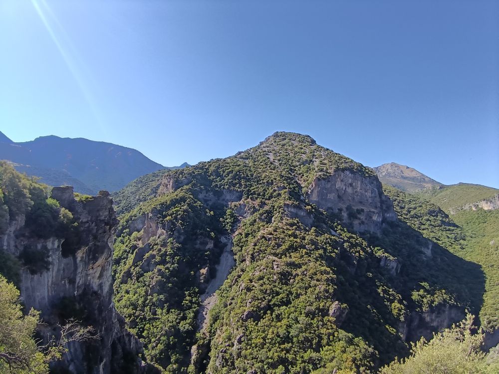 A mountainscape under a blue sky.