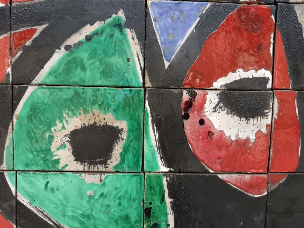 Two eyes from a work by Joan Miró and ceramist Joan Gardy Artigas. Paint on ceramic. The eyes themselves are large black stains, one against a green backdrop, the other against a red backdrop.