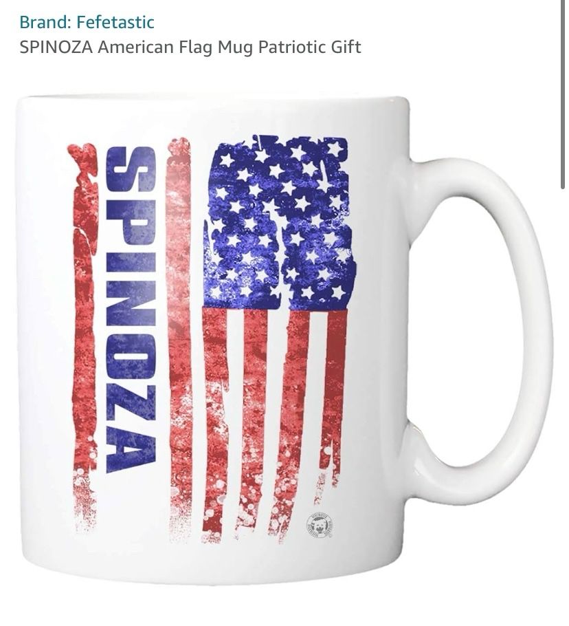 Coffee mug featuring a vertical print of a tacky American flag with the words “SPINOZA” appearing on the bottom half of the flag. At the top of the screen in a font often used on Amazon are the words “SPINOZA American Flag Mug Patriotic Gift.”