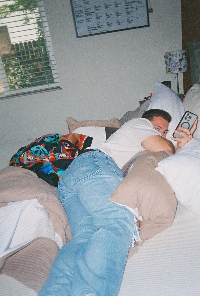 Chef lying on his bed scrolling his phone 