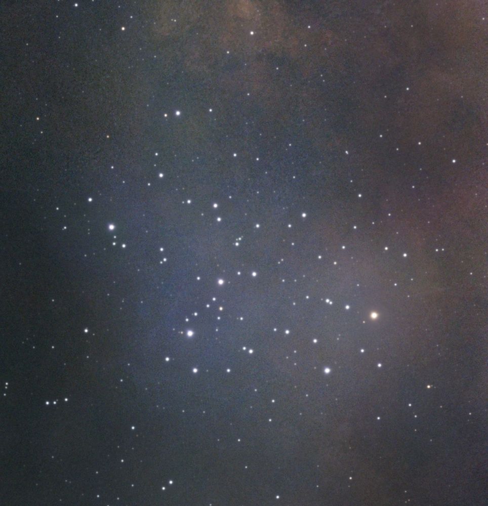 M6 in this image is a group of around 20-30 stars that are about 1600 light years from Earth. It is not a tight cluster, and some of the stars form V shapes. They are surrounded by a blue nebulosity. In the top right-hand corner is more nebula, although it is more of a traditional brown-orange colour.