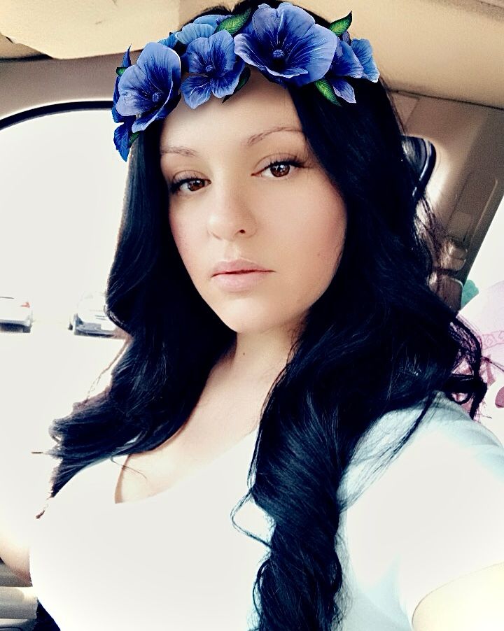 A woman with black hair and a blue flower crown 