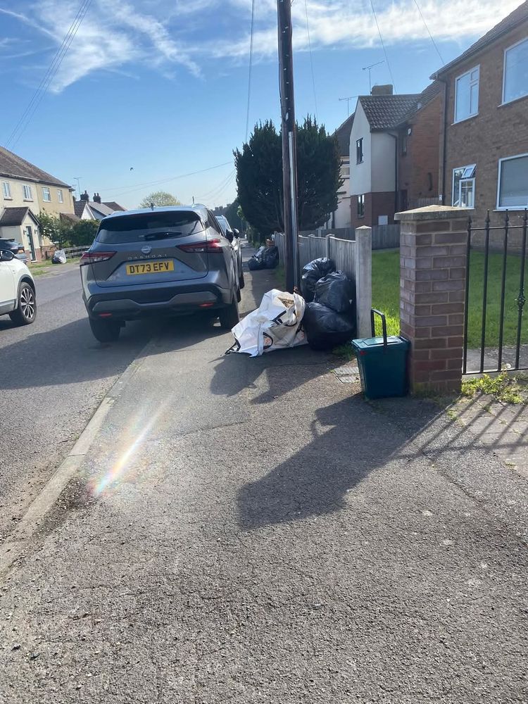 Picture shows a car parked partially on the pavement, a telegraph pole and the weekly refuse bags that combine to make the pavement blocked