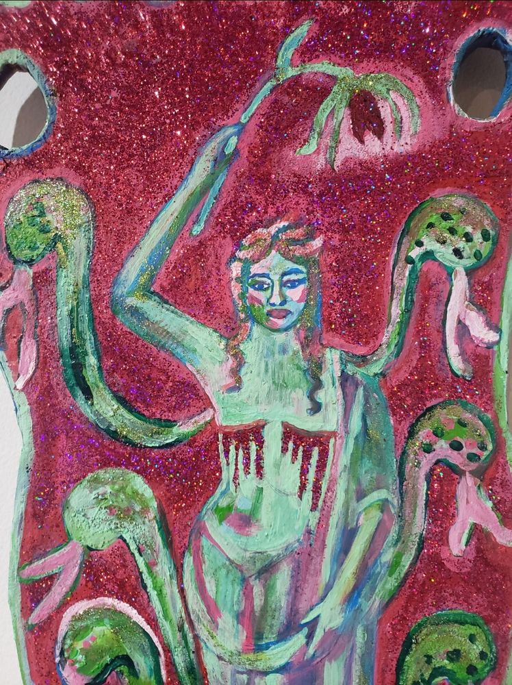 A red glittery vase with a nonbinary flower deity, part human, part cobra lily