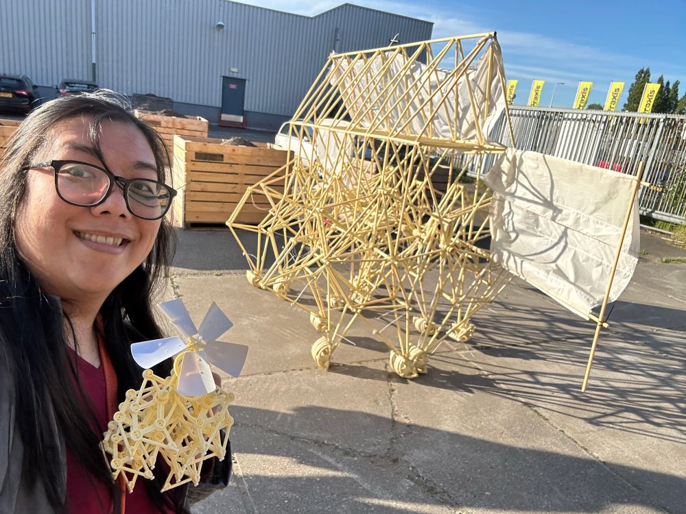 Kate holding her tiny kit strandbeest in front of a full sized one