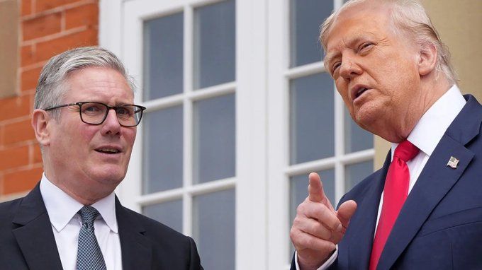 Trump meeting Scotland during a meeting with United Kingdom Prime Minister Keir Starmer. Both engaged in conversation outdoors, with Trump gesturing while dressed in a suit and red tie. Starmer looking at direction Trump is pointing, mouth agape and seemingly confused.