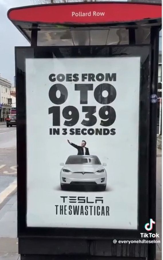 Bus stop poster of Tesla swasticar, Musk doing the Hitler salute and the slogan “from 0 to 1939 in three seconds.”