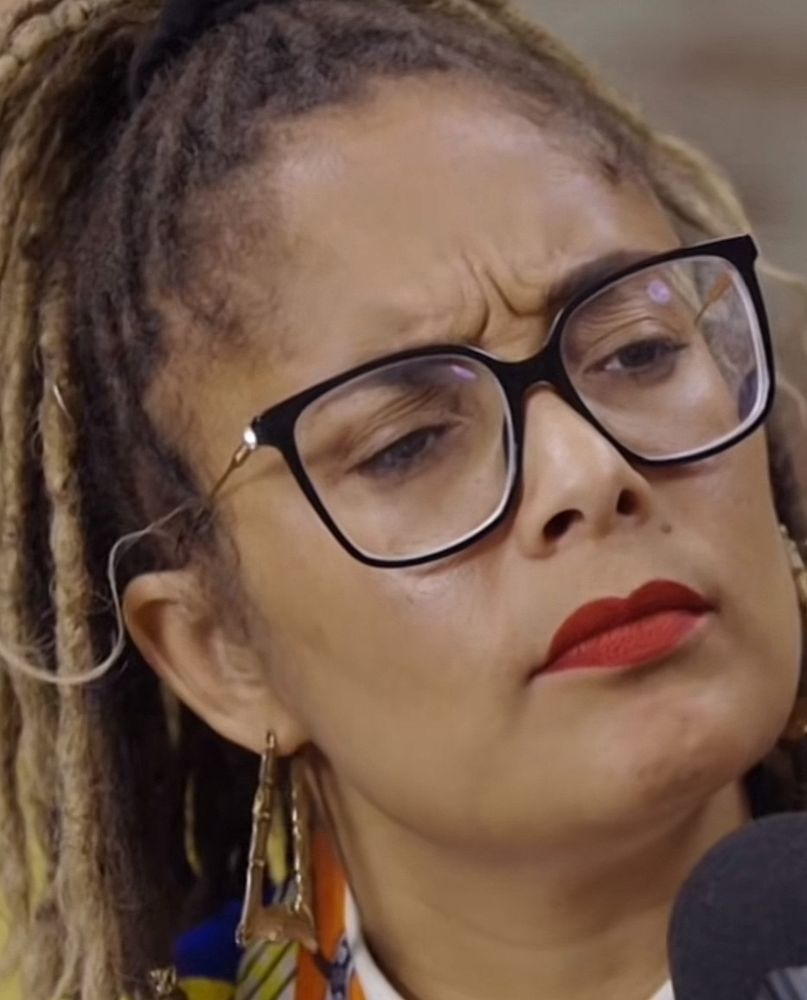 A close-up of Amanda Sealed furrowing her brows and looking irritated/concerned