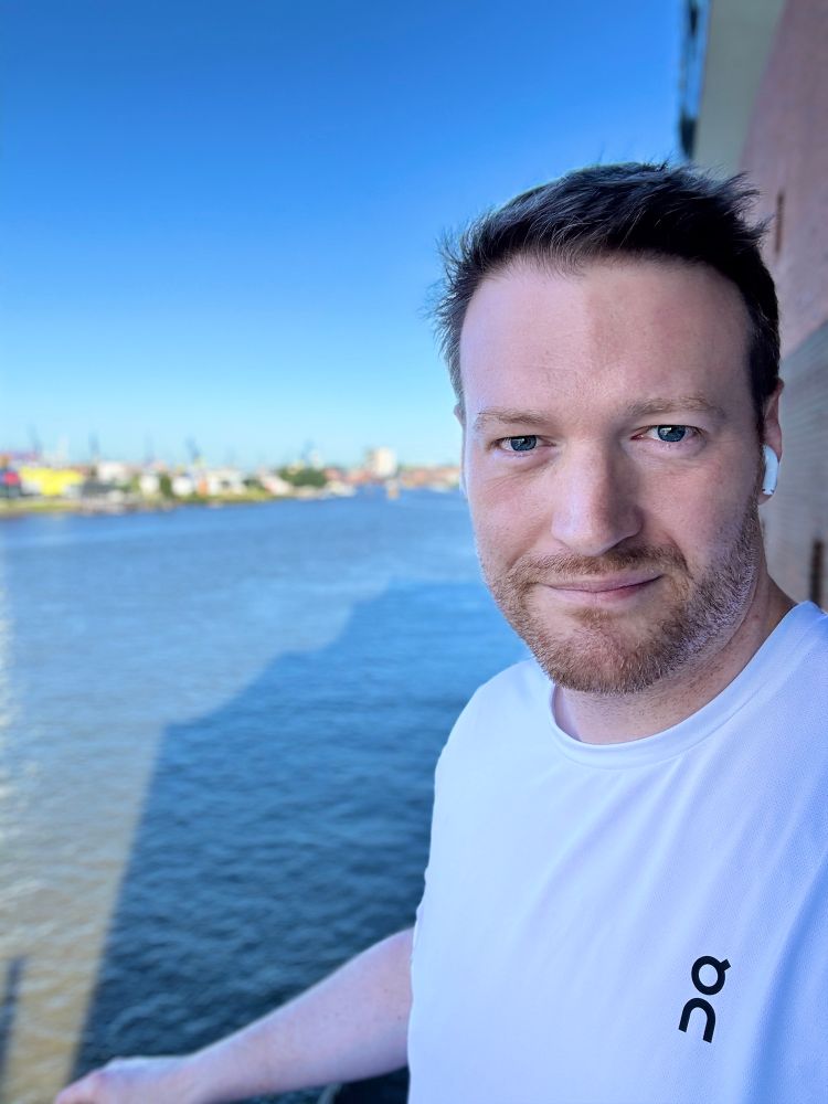 Selfie von Tobias Raab in Hamburg mit dem Hafen im Hintergrund.
