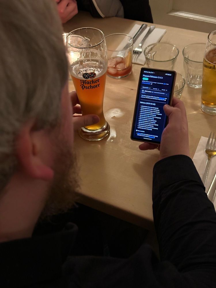 A picture taken over my shoulder of me releasing Embroider@v4 from my phone while drinking a beer in a restaurant 
