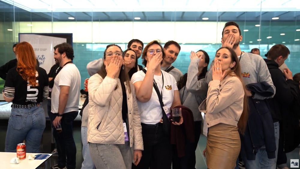 Un grupo de varias personas lanzan un beso al aire.