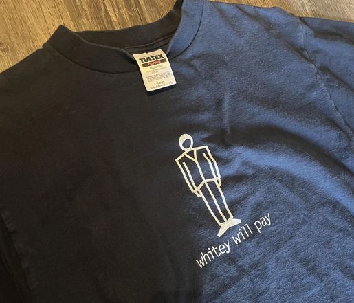 black t-shirt with "whitey will pay" legend