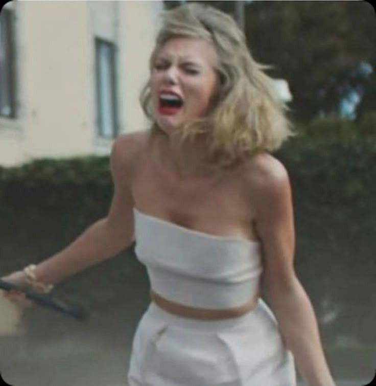 Taylor Swift is crying and screaming wearing a white crop top and bottoms