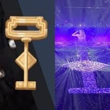 A golden key on the left shaped like the eras tour stage on the right