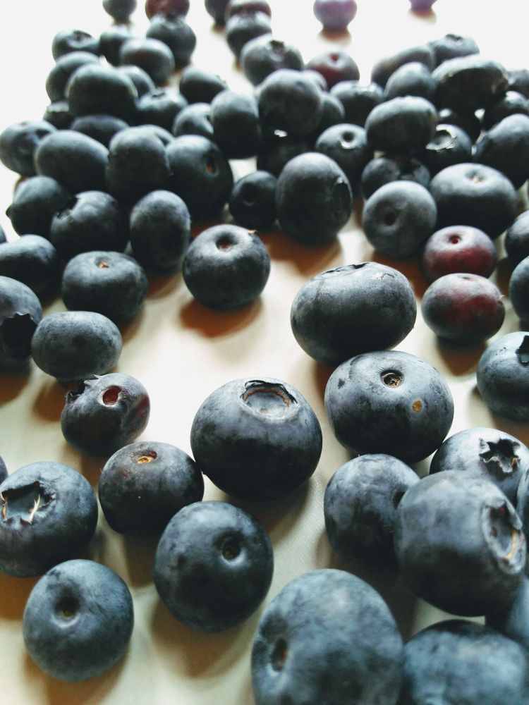 Fresh blueberries on a beige table.

