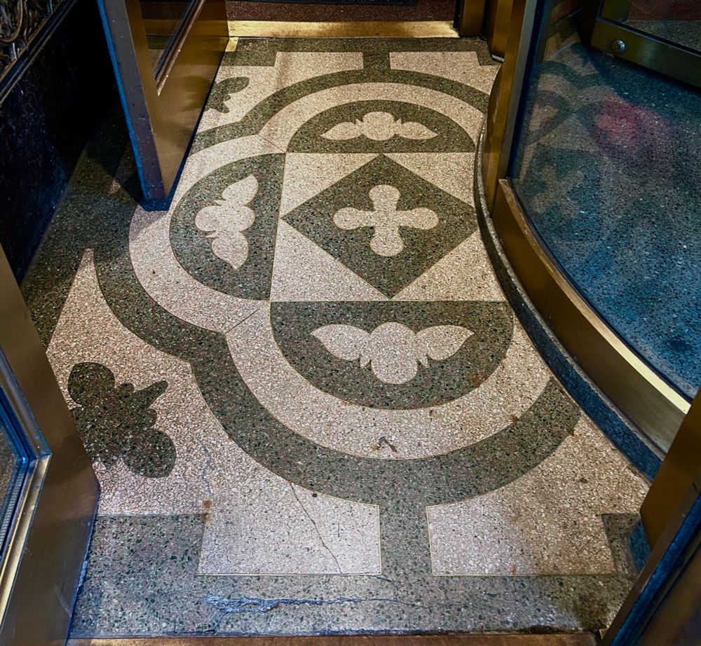 A terrazzo floor with a bee and floral pattern.