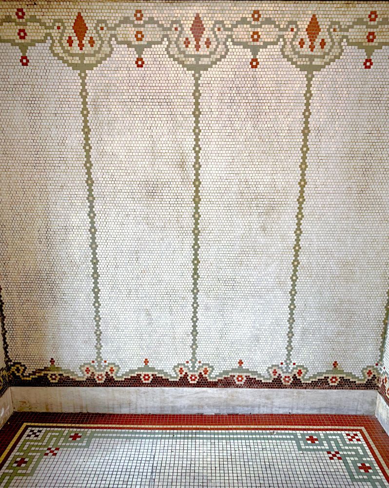 A circa 1910 apartment entrance hallway in with mosaic tiled walls and floors.