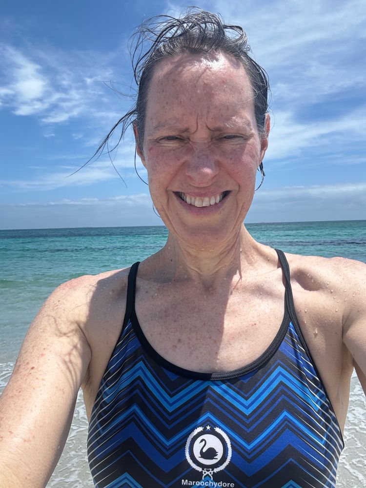 A woman in a bathing suit with the sea behind her