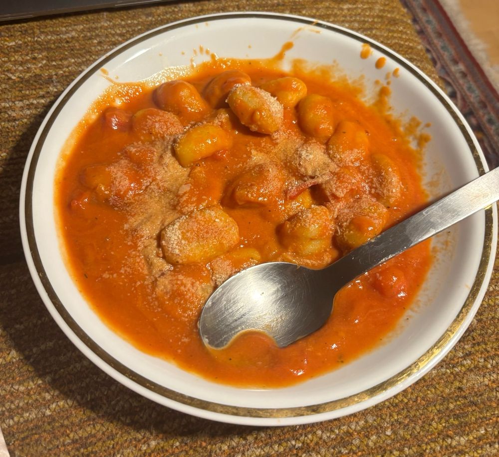 Teller mit Gniocci in Tomatensoße und Hefeflocken 